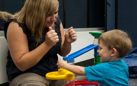 Photo of woman playing with young boy.