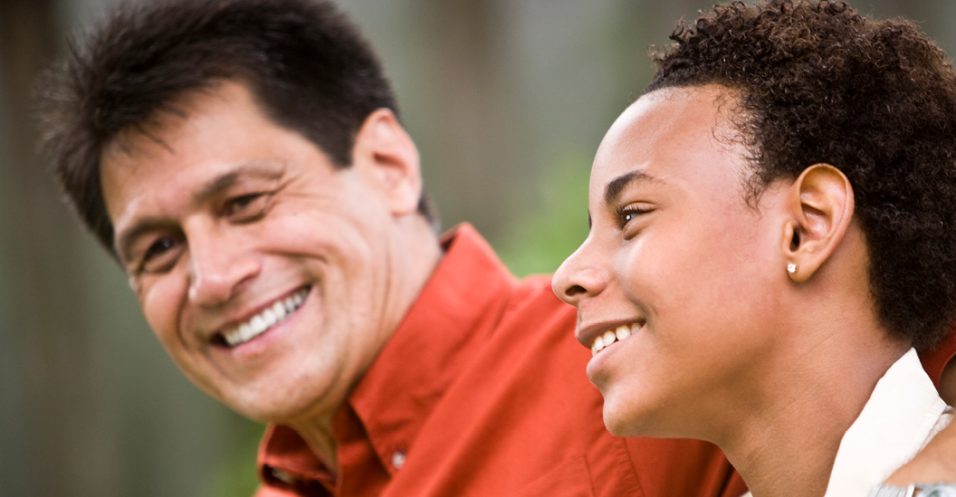 Father and adult son smiling