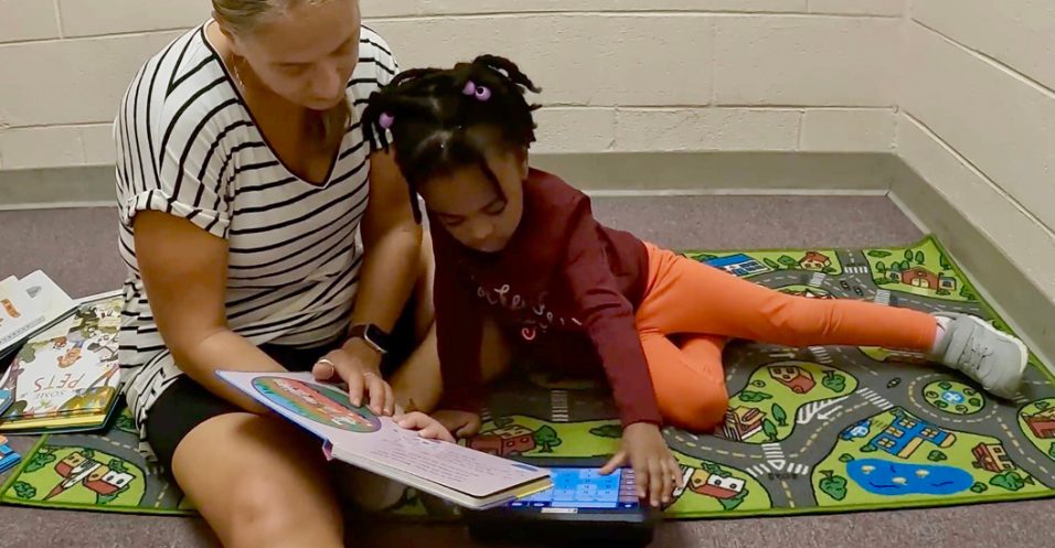 Girl using a phonetic keyboard with a woman