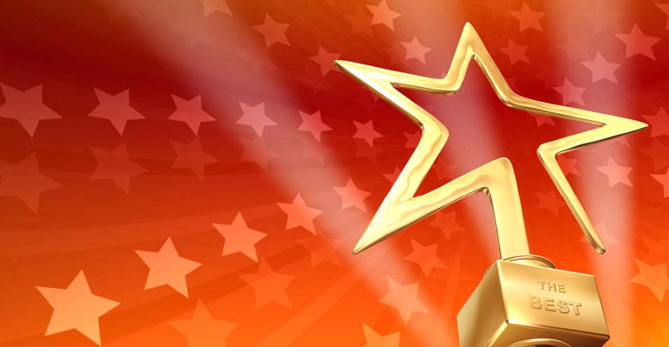 Gold star-shaped award trophy on a red background patterned with lighter star shapes.