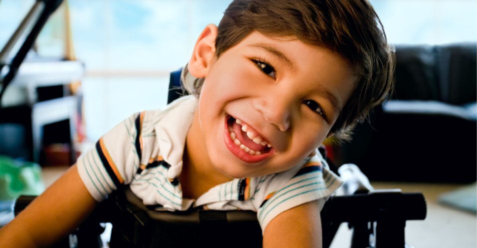 Happy smiling little boy standing in walker.